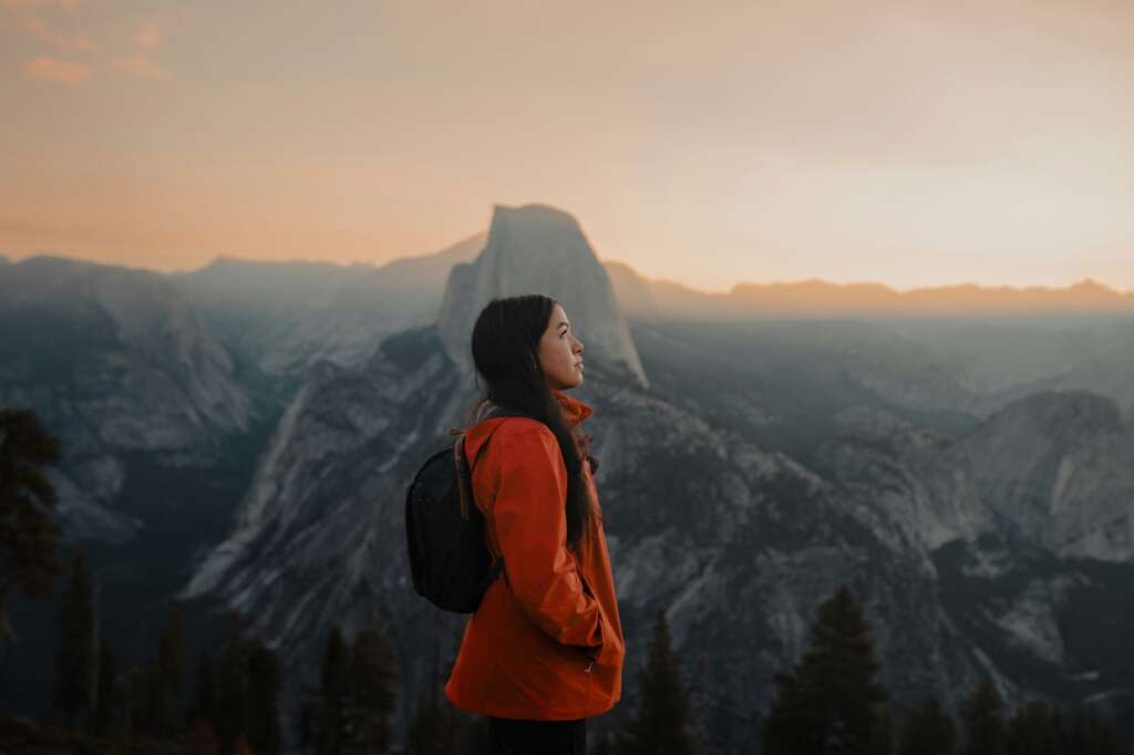 Person in orange jacket, mountain view.
