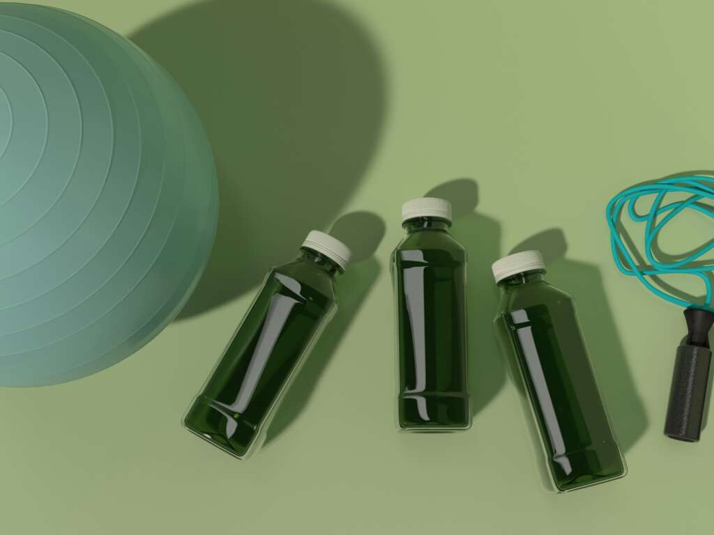 Wellness products arranged for testing, including bottled drinks, a yoga ball, and a jump rope on a minimal studio background.