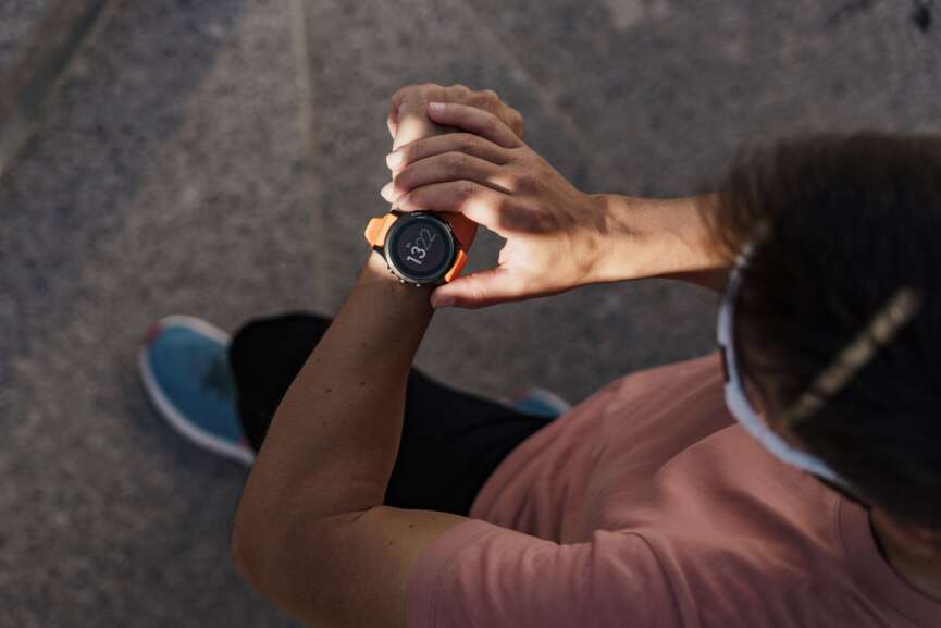 Person, die eine Sport-Smartwatch w&auml;hrend eines Trainings im Freien &uuml;berpr&uuml;ft.